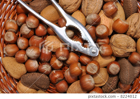 some organic nuts in a basked and a nutcracker some organic nuts in a basked and a nutcracker 8224012