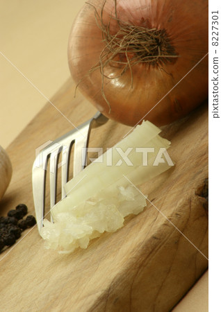 sliced organic onion and a fork on a timber board 8227301