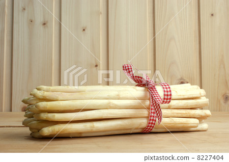 some organic asparagus on a timber plate 8227404
