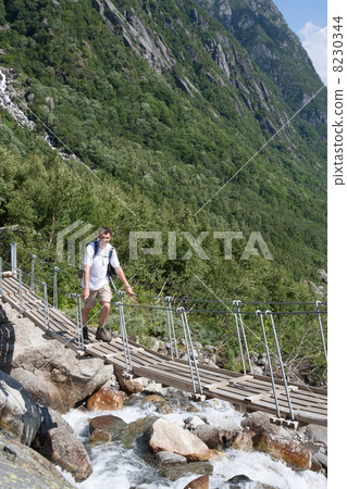 Man on Bridge over a waterfall (Buerdalen valley, Norway) 8230344