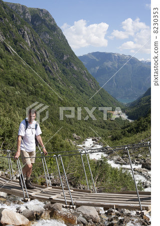 Man on Bridge over a waterfall (Buerdalen valley, Norway) 8230353