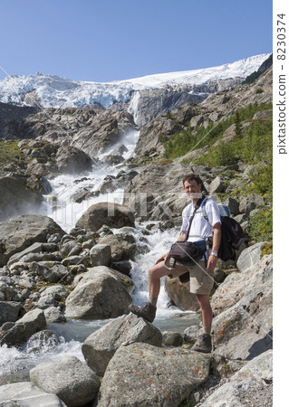 Man and a waterfall (Buarbreen glacier, Folgefonna National Park 8230374
