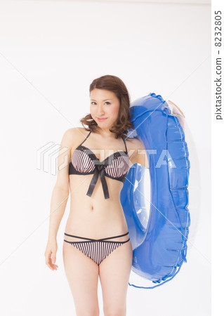 A woman in a bathing suit with a floating ring A woman in a bathing suit with a floating ring 8232805