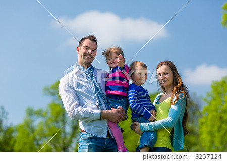 Happy family standing in summer meadow Happy family standing in summer meadow 8237124