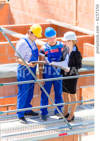 Team discussing construction or building site plans 8237150