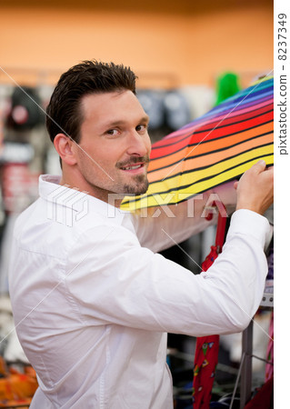 Handsome Man Buying Umbrella at Supermarket 8237349