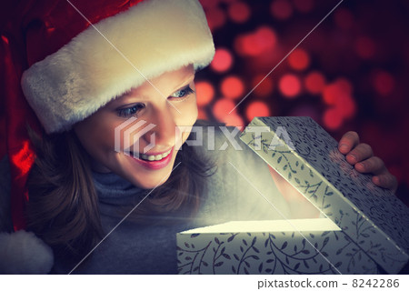 happy woman in a Christmas cap opens the magic box 8242286