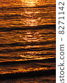 The reflection of the setting sun on the waves in the ocean 8271142