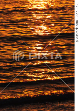 The reflection of the setting sun on the waves in the ocean 8271142