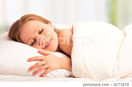 beautiful woman sleeping and smiles in his sleep in  bed 8271678