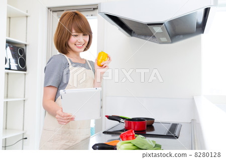 烹調的婦女,當觀看片劑時 烹調的婦女,當觀看片劑時 8280128