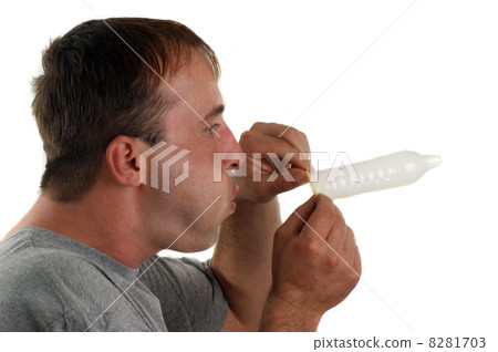 young man with a gray T-shirt blows in a condom young man with a gray T-shirt blows in a condom 8281703