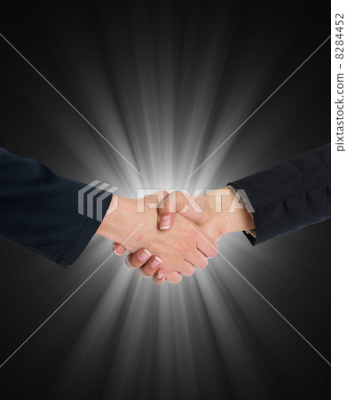 Handshaking in front of blue light Handshaking in front of blue light 8284452