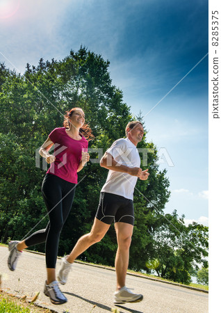 Young couple jogging in a park Young couple jogging in a park 8285375