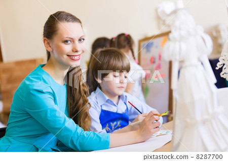 Children painting with teacher 8287700