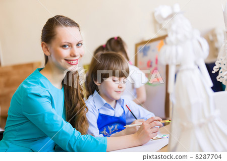 Children painting with teacher Children painting with teacher 8287704