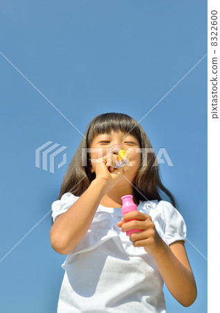 A girl playing bubbles in the blue sky A girl playing bubbles in the blue sky 8322600