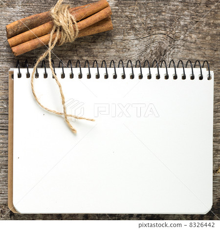 Blank Recipe book with bunch of cinnamon on old wood board 8326442