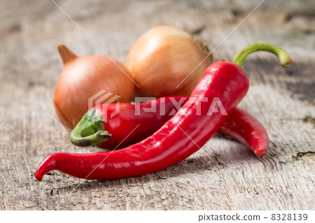 Red chili pepper with onion at wood background. Selective focus Red chili pepper with onion at wood background. Selective focus 8328139