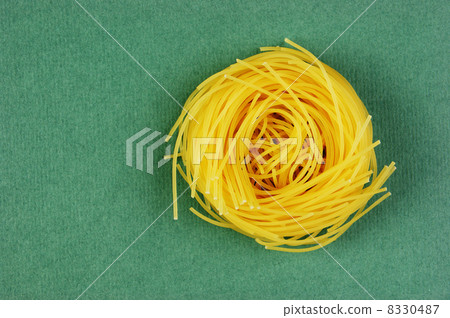 Tagliatelle pasta background on the green background 8330487