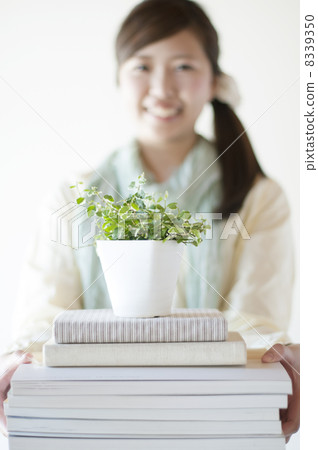 拿著書和植物和微笑的婦女 拿著書和植物和微笑的婦女 8339350