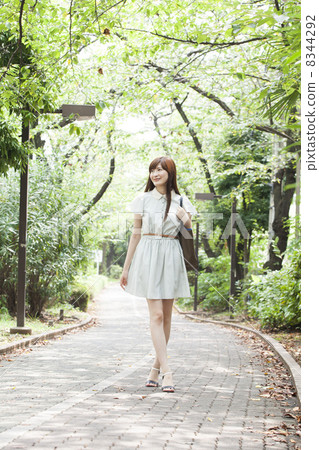 A woman walking on the green road A woman walking on the green road 8344292