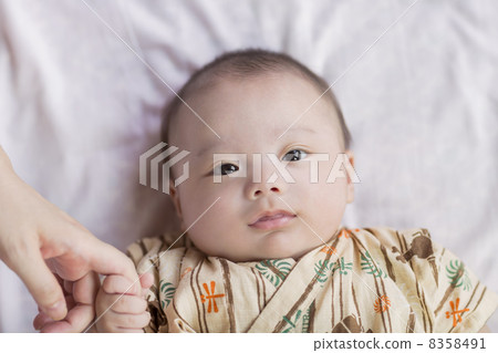 抱著母親的手指的嬰兒 8358491