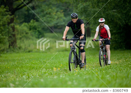 Man and woman riding bicycles 8360749