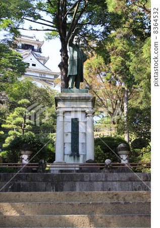 在高知城堡內，一座退休的鈴木雕像和一座城堡塔樓 8364532
