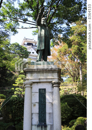 在高知城堡內，一座退休的鈴木雕像和一座城堡塔樓 8364533