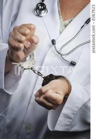 Doctor or Nurse In Handcuffs Wearing Lab Coat and Stethoscope 8367625