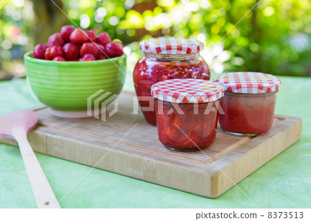 Homemade strawberry jam in different jars and fresh ripe strawbe 8373513