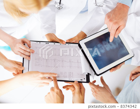 group of doctors looking at x-ray on tablet pc 8374342