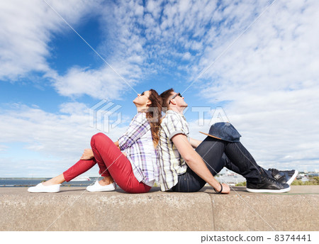 teenagers sitting back to back 8374441