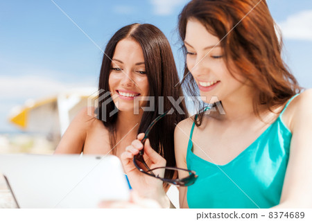 girls looking at tablet pc in cafe girls looking at tablet pc in cafe 8374689