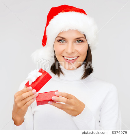 smiling woman in santa hat with small gift box smiling woman in santa hat with small gift box 8374979