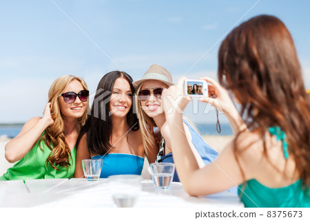 girls taking photo in cafe on the beach 8375673