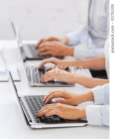 group of people working with laptops in office 8376109