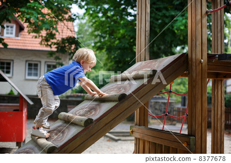 Little toddler boy sitting on playground Little toddler boy sitting on playground 8377678