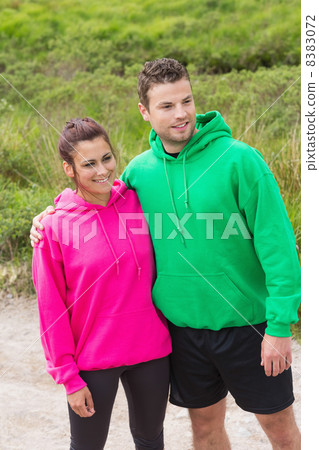 Athletic couple looking ahead and embracing Athletic couple looking ahead and embracing 8383072