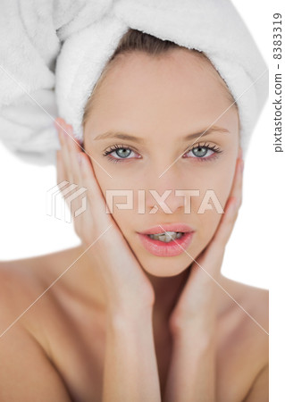 Thinking brunette drying her hair looking at camera Thinking brunette drying her hair looking at camera 8383319