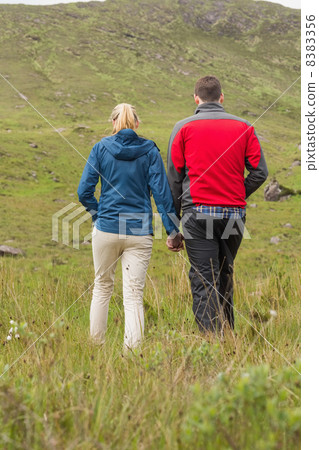 Couple holding hands and walking 8383356