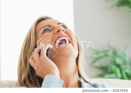 Laughing woman calling someone with her mobile phone Laughing woman calling someone with her mobile phone 8383560