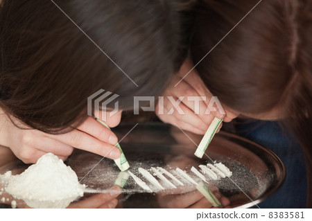 Two girls snorting an illegal white powder 8383581