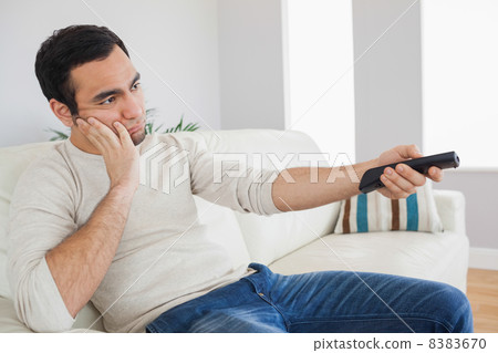 Handsome man getting bored of tv programs Handsome man getting bored of tv programs 8383670