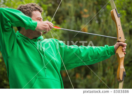 Man in green jumper about to shoot arrow Man in green jumper about to shoot arrow 8383886