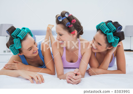 Laughing friends lying in bed Laughing friends lying in bed 8383991