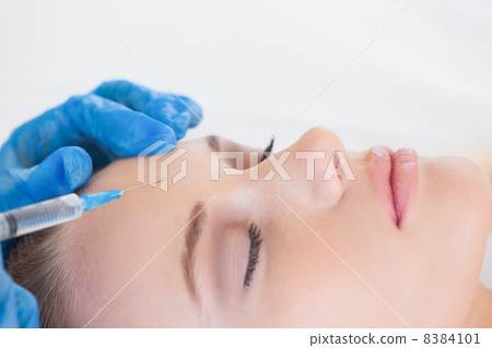 Surgeon making injection on natural woman lying Surgeon making injection on natural woman lying 8384101