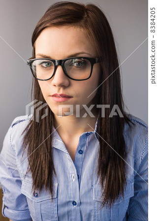 Serious pretty brunette wearing glasses posing Serious pretty brunette wearing glasses posing 8384205