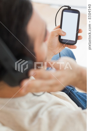 Close up on young man using his smartphone to listen to music Close up on young man using his smartphone to listen to music 8384540